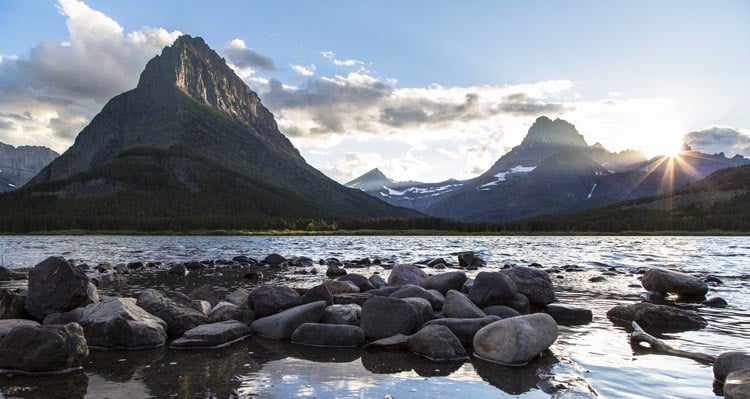 A view of mountains at sunset across Swiftcurrent Lake