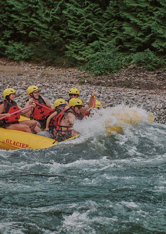 A wave tips into a raft full of people