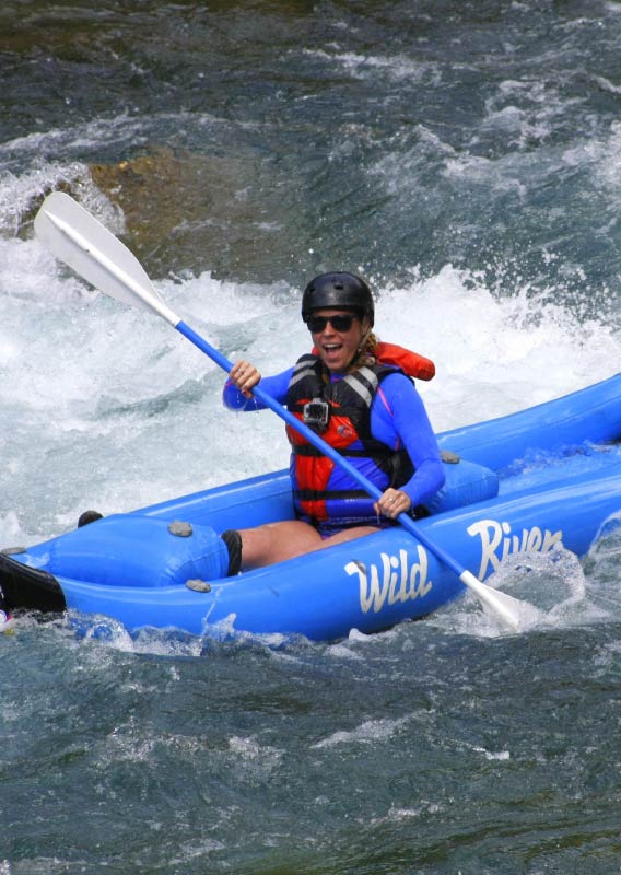 A kayaker paddles through a rushing river