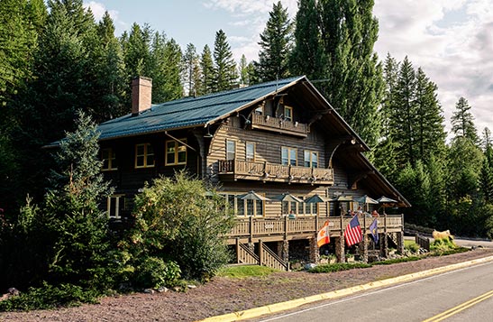 A wooden lodge building next to a small road.