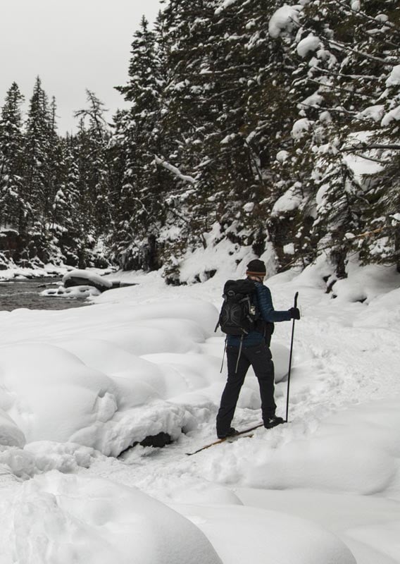 A cross country skiier on a snow-covered path along McDonald Creek