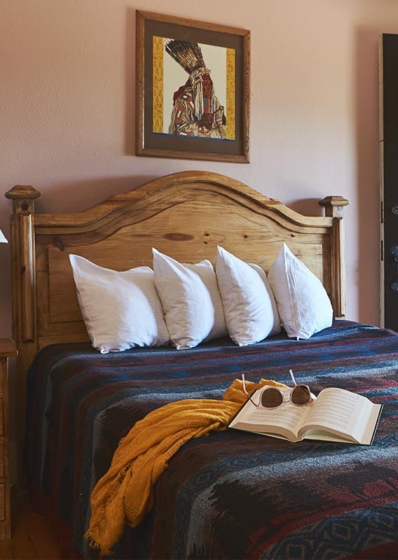 a book, sunglasses and a blanket on a bed