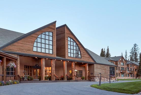 Grouse Mountain Lodge, a wooden lodge, against a blue sky.