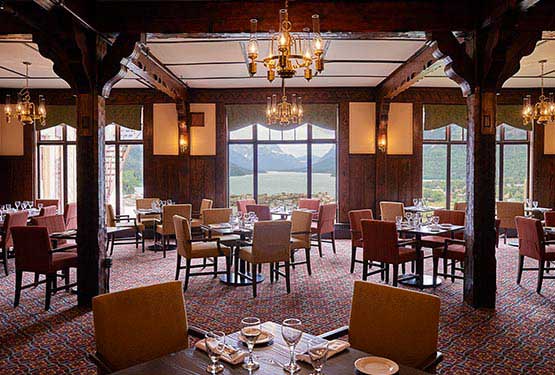 Dining tables in a large dining room next to a large window.