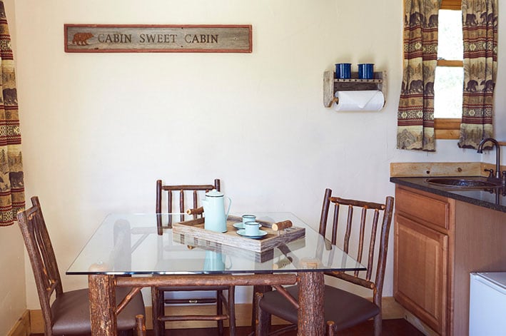 Dining table and kitchen in a Glacier Cabin at St. Mary Village