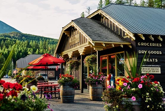 A wooden building with flowerpots all around.