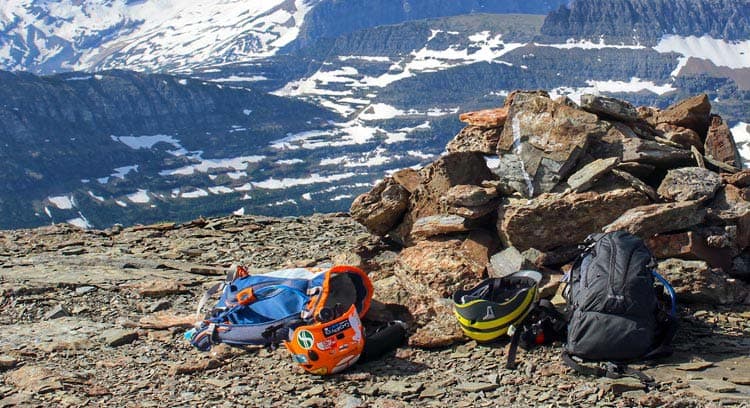 Safety gear resting on the ground with a mountain backdrop