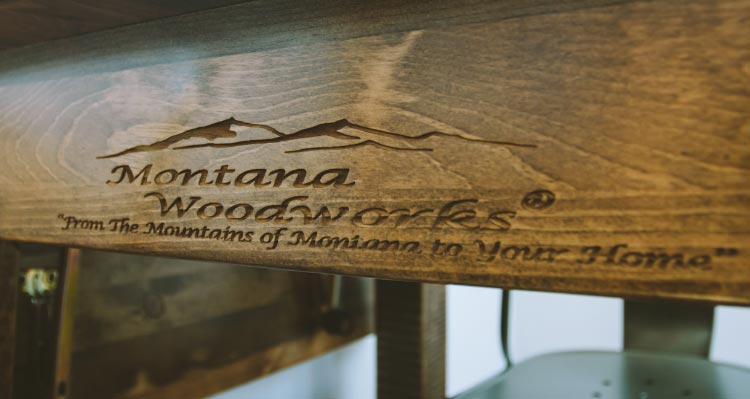 The underside of a table shows the Montana Woodworks logo engraved.