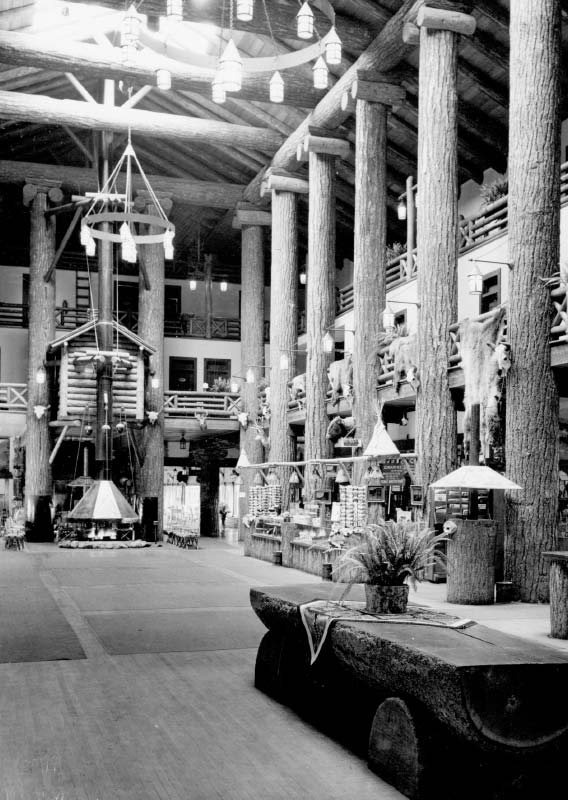 The interior of a rustic lodge with tall tree-trunk beams.