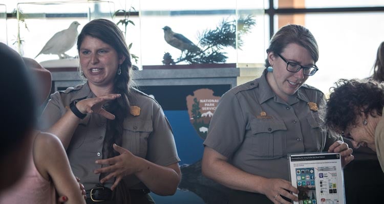Two National Park rangers talk to visitors.