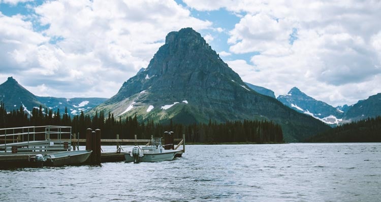 A prominent rocky mountain rises behind a crisp lake.