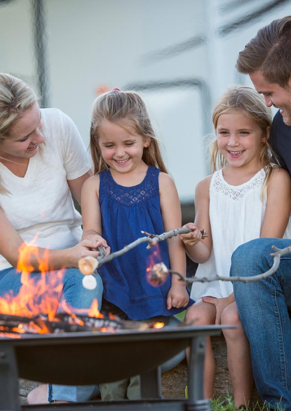 A family roasts marshmallows over a firepit.