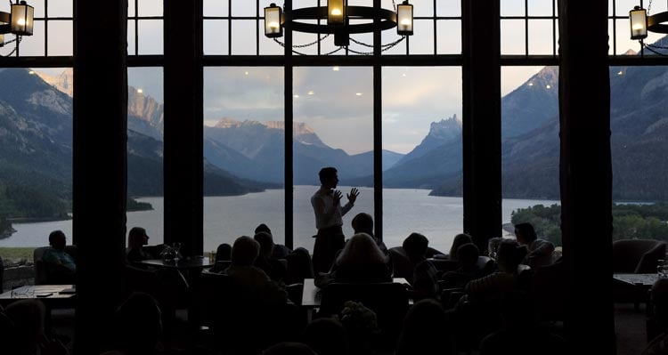 An interpreter gives a talk in front of a tall expansive window.