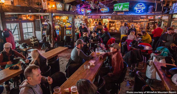 A cozy cabin-style bar filled with people sitting around tables