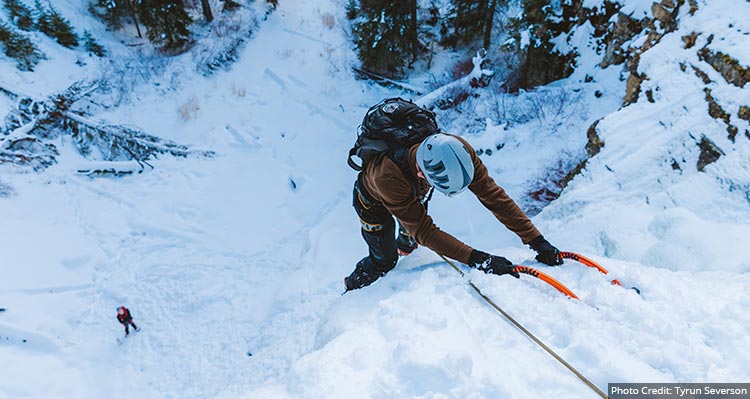 An ice climber on the side of a frozen waterfall