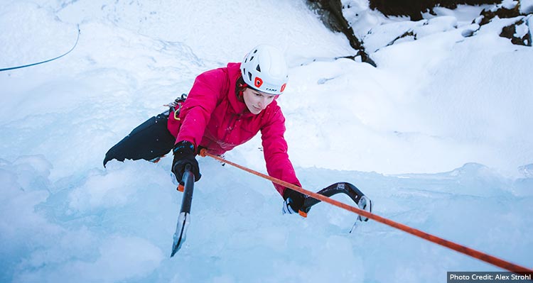 An ice climber on the side of a frozen waterfall