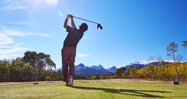 A golfer takes a big swing.