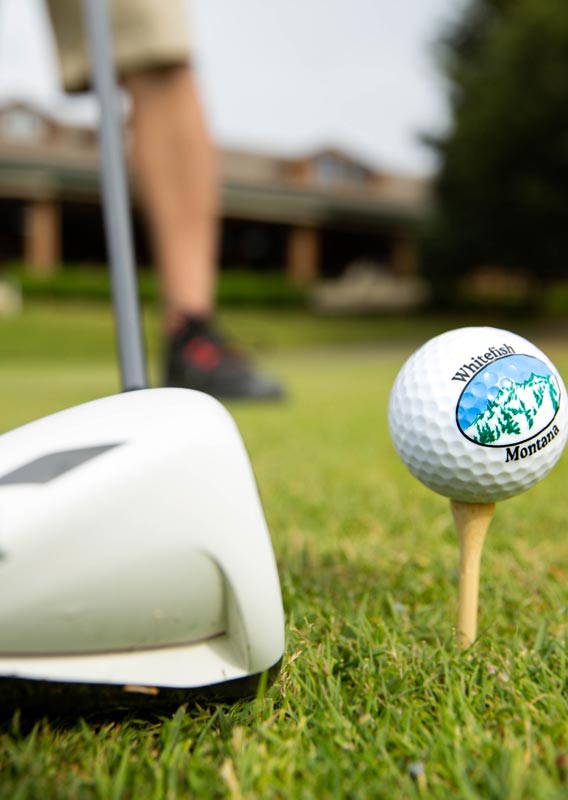 A golf club and golf ball on a tee