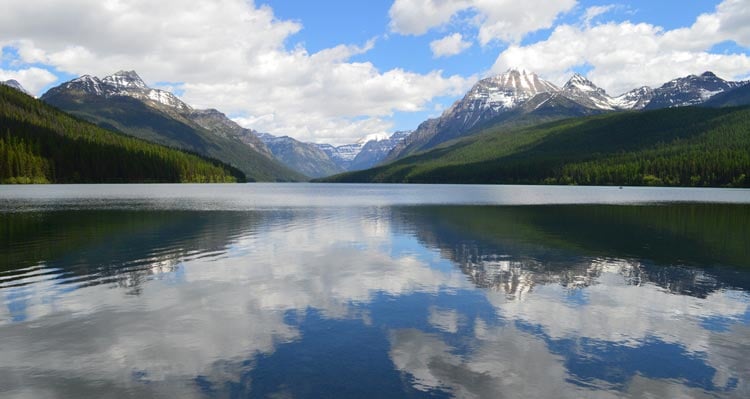 A clear lake between forested mountainsides