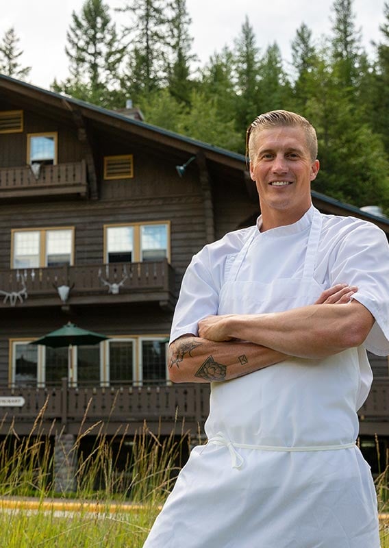 A chef stands in front of the wooden Belton Chalet