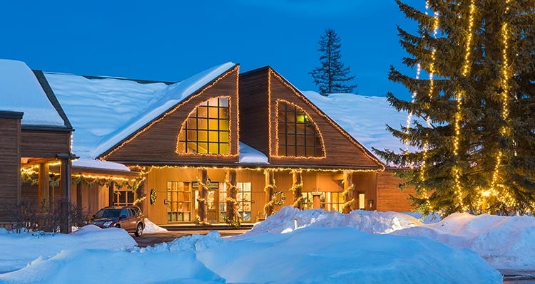 The Grouse Mountain Lodge covered in snow and decorated with Christmas lights.