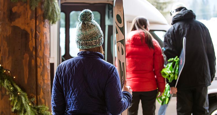 Skiers get onto a bus outside of Grouse Mountain Lodge