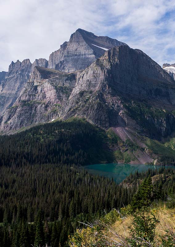 A landscape view of mountains above a blue lake and forests.