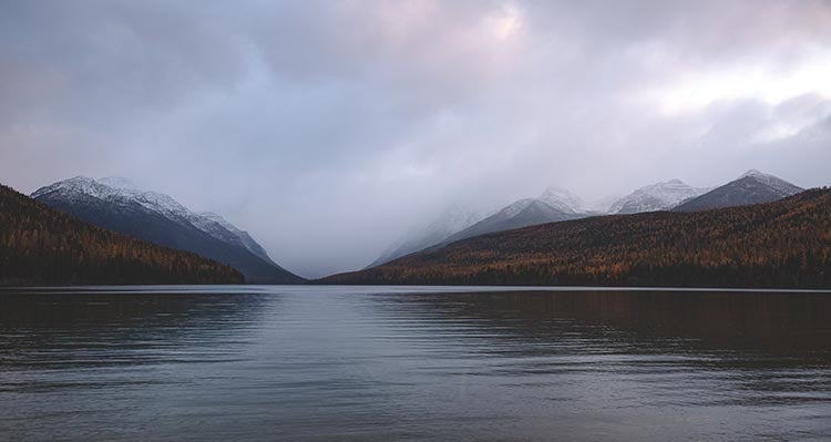 A lake before a misty valley.