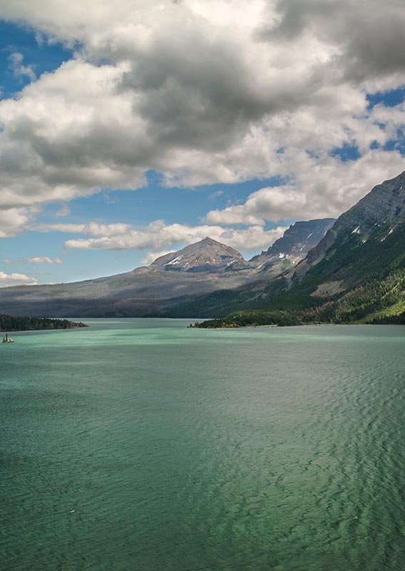 A view across a lake between mountains, looking out towards the plains.