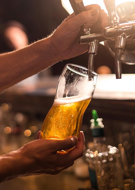 A beer getting poured from a bar tap.