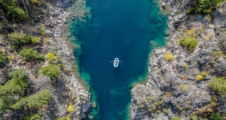 An areal photo of a raft floating down the middle of the river.