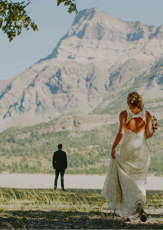 Bride running towards groom under mountains