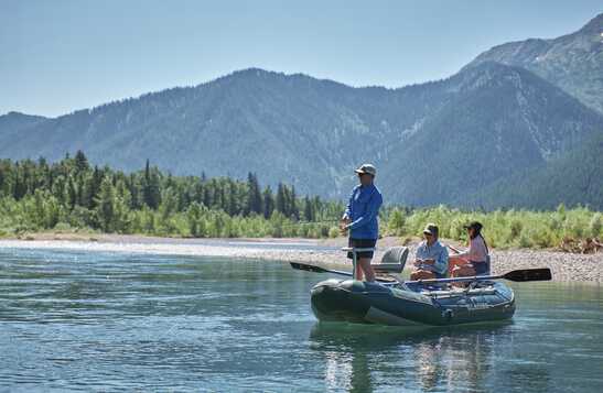 A man and two women on a boat fishing.