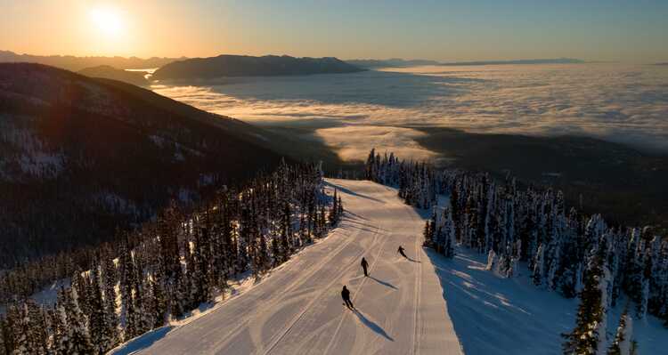 Group of people downhill skiing during Golden Hour