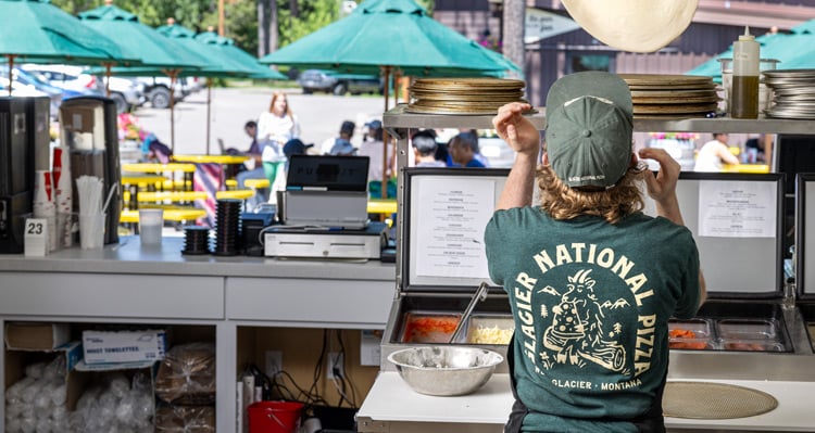 Glacier National Pizza employee tossing pizza dough
