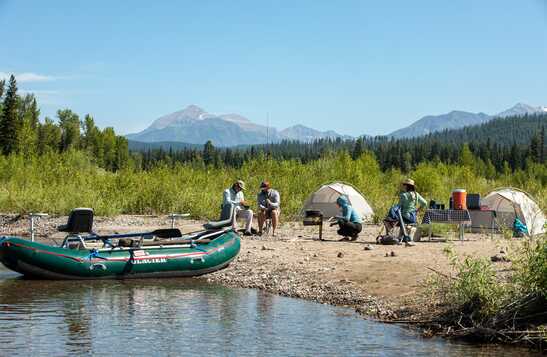 A fishing group relaxing on the beach beside the Flathead River
