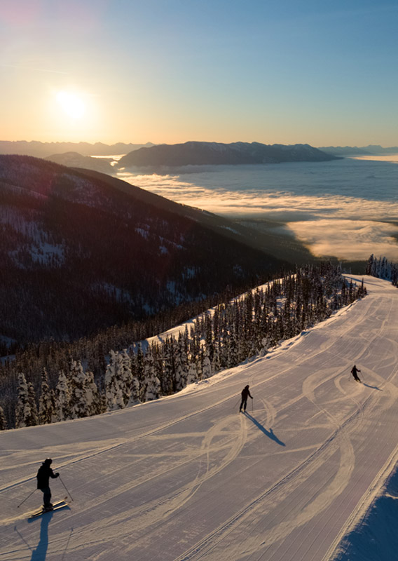 An aerial view of three people skiing down a mountain.