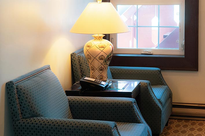 Luxurious hotel suite with a large sitting area and separate bedroom with one king bed