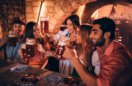 A group of people raising stein glasses of beer at a celebration.