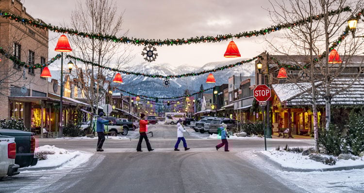 A family crossing the street in Whitefish village during the winter holidays