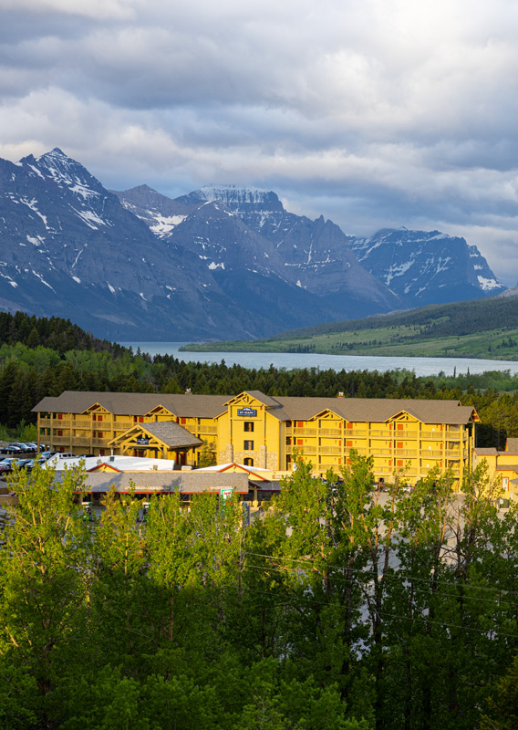 A birds eye view of St. Mary Village with mountains and a river in the background.