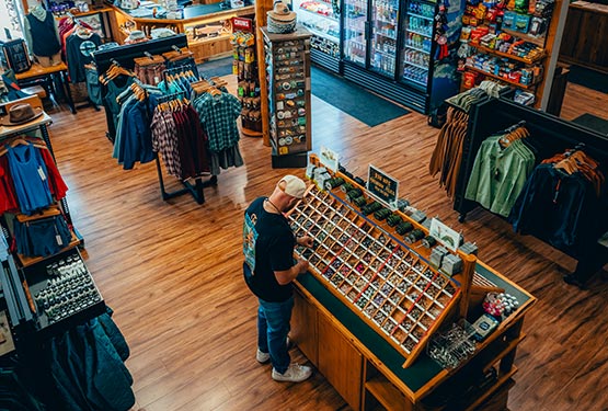 A person looks at fishing flies in a shop.