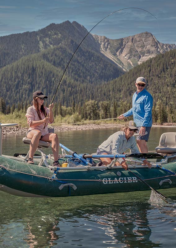 Three people fishing on a clear reflective river.