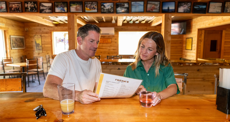 A couple reading a menu while drinking coffee