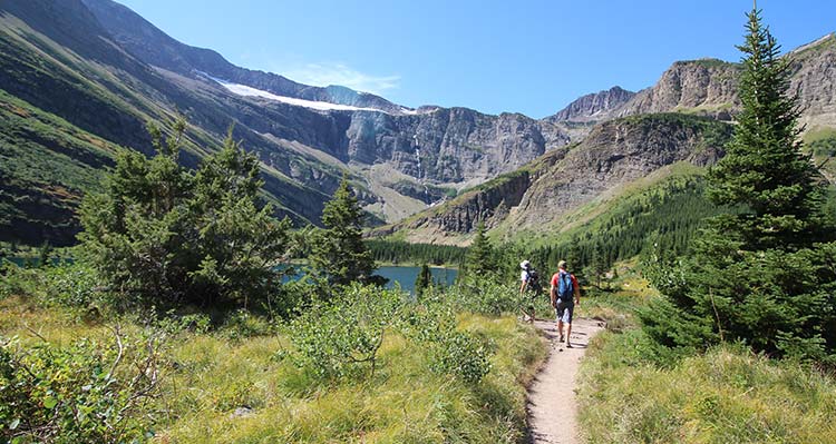 Two people hiking on an outdoor trail.