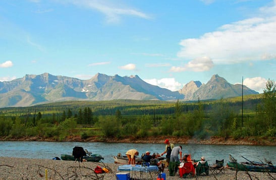 A rafting group relaxing on the beach, looking at the mountain view