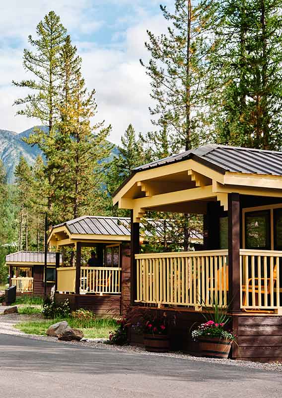 Couple biking past beautiful wood cabins
