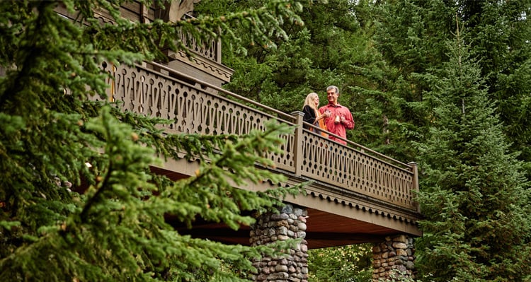 A couple standing on a balcony at the Belton Chalet