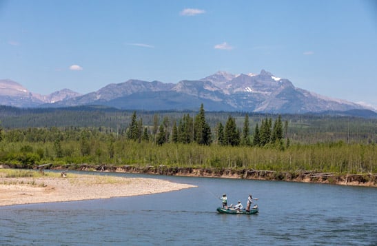 Aerial view of people fishing in a boat on the Flathead River, with a mountain view