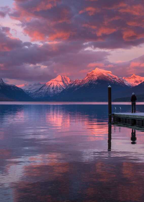 A landscape view of the sunrise across a calm lake.